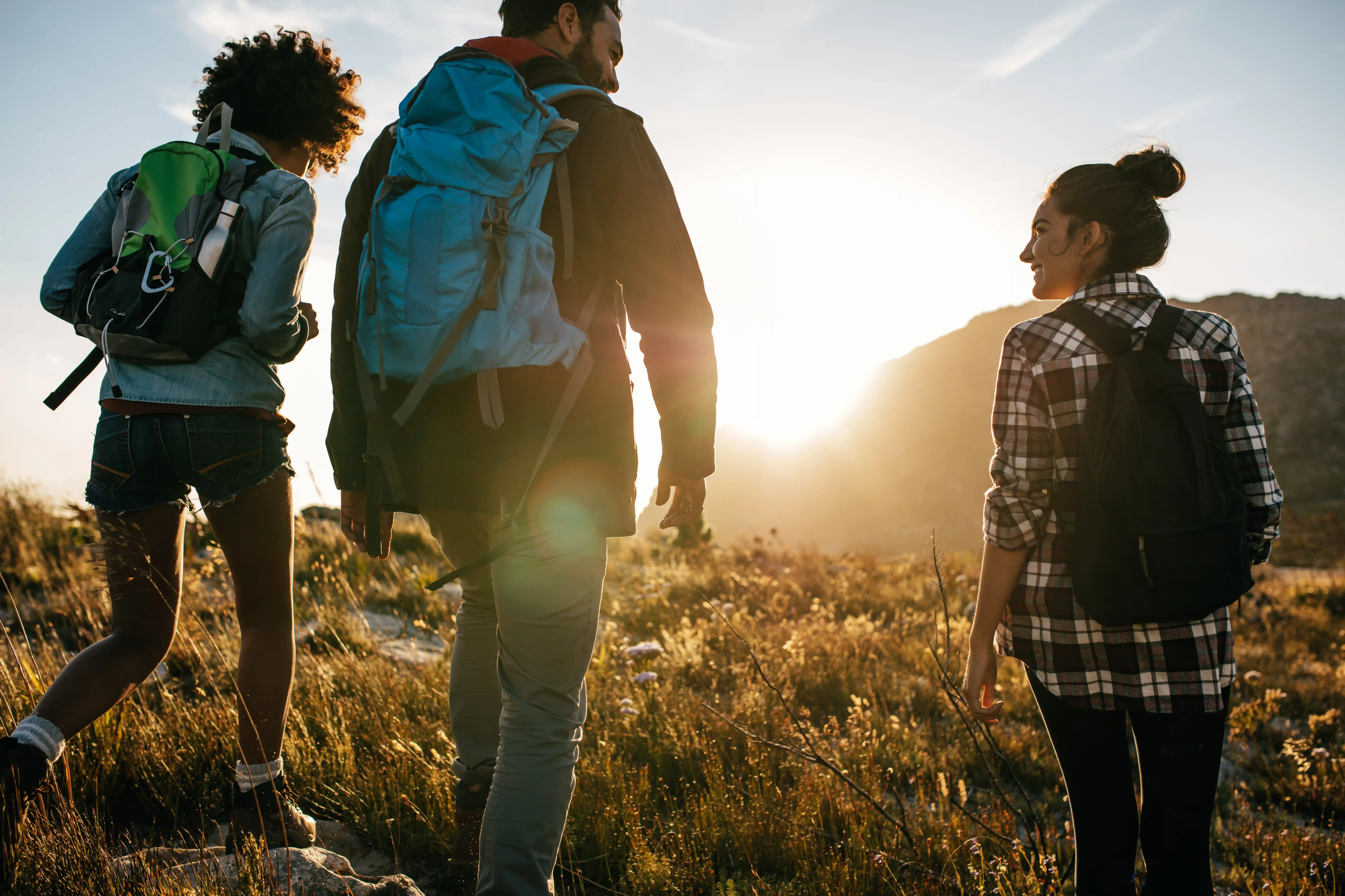Three friends hiking in the hills at sunrise